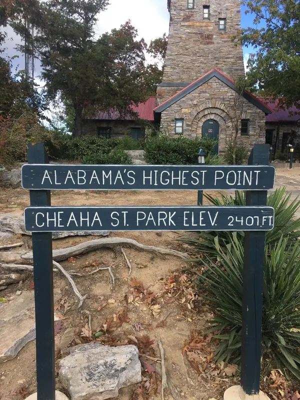 sign reading Alabama's Highest Point Cheaha St Park in front of the old stone building